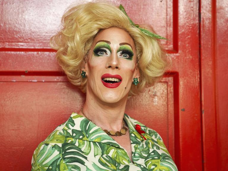 Gaby Tupper mit Blitzlicht porträtiert vor einer roten Tür.