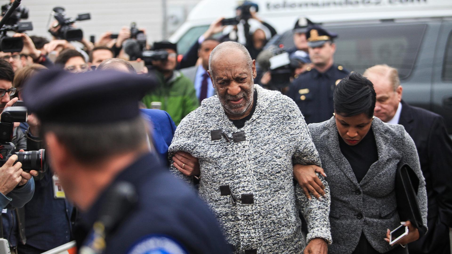 Der Schauspieler Billy Cosby, umgeben von einer Menschenmenge. Darunter sind Polizisten in Uniform. Der Schauspieler Billy Cosby, umgeben von einer Menschenmenge. Darunter sind Polizisten in Uniform.