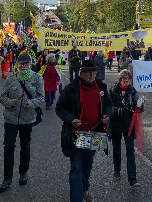 Meist ältere Menschen demonstrieren auf einer Straße gehend gegen Atomkraft und den Weiterbetrieb des AKW Neckarwestheim.