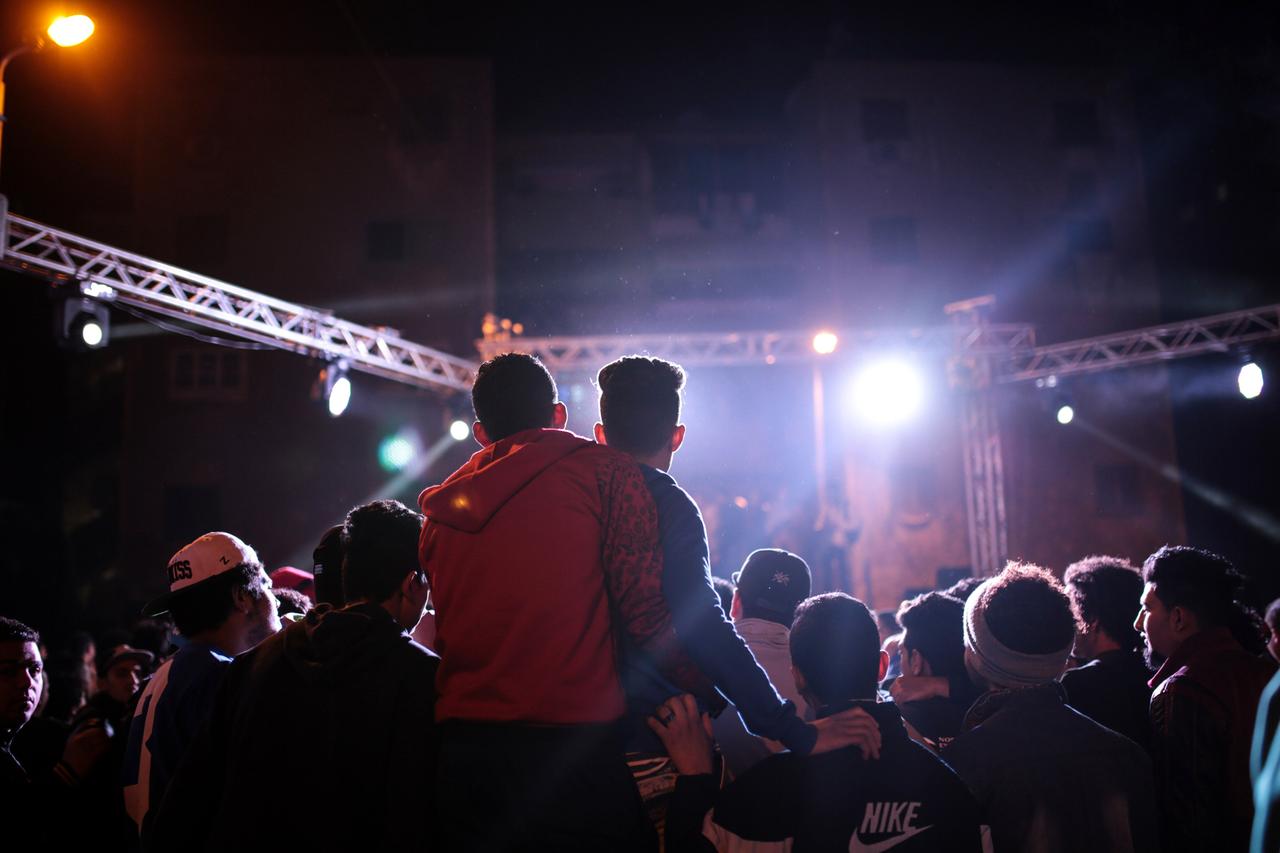 Abendaufnahme einer Gruppe von Menschen bei einer Musikveranstaltung.