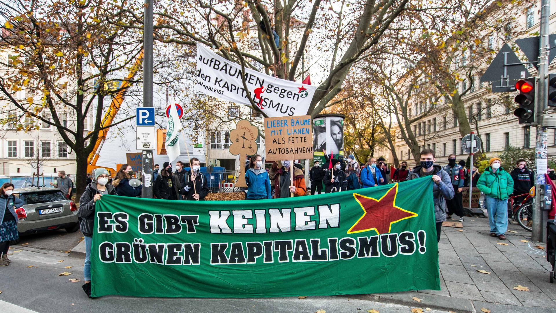 Junge Menschen halten Plakat mit der Aufschrift "Es gibt keinen grünen Kapitalismus" bei einer Demonstration. Junge Menschen halten Plakat mit der Aufschrift "Es gibt keinen grünen Kapitalismus" bei einer Demonstration.