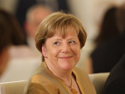 Angela Merkel sitzt bei einem Staatsbankett zu Ehren von König Charles im Schloss Bellevue.