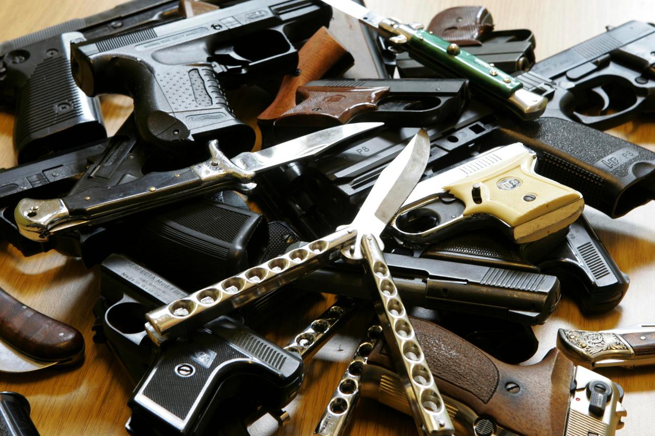 Ein Haufen von der Polizei bei Jugendlichen sichergestellte Waffen. Darunter Schreckschusspistolen, Klappmesser und Butterflymesser.
