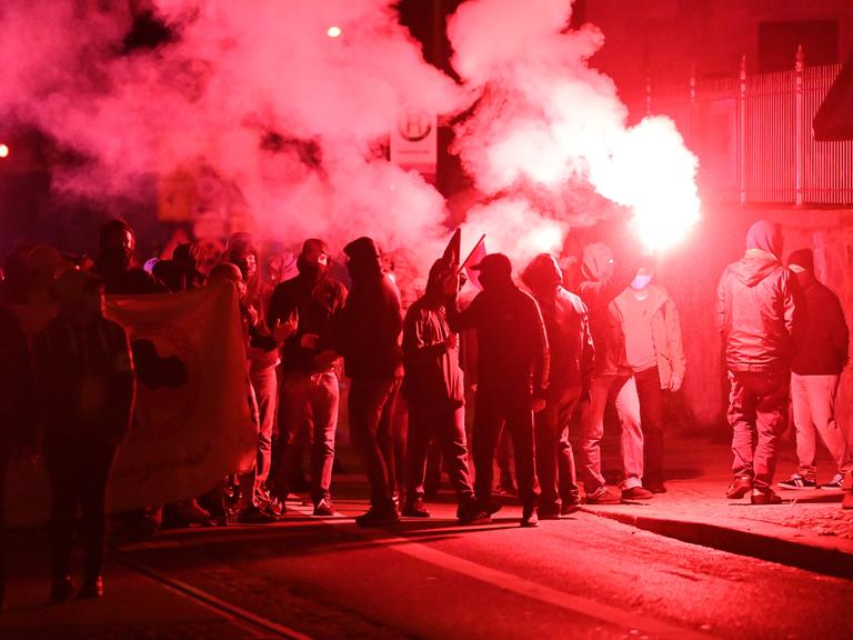 Teilnehmer einer Demonstration ziehen mit roten Pyro-Fackeln durch den Leipziger Stadtteil Connewitz, 2020. 