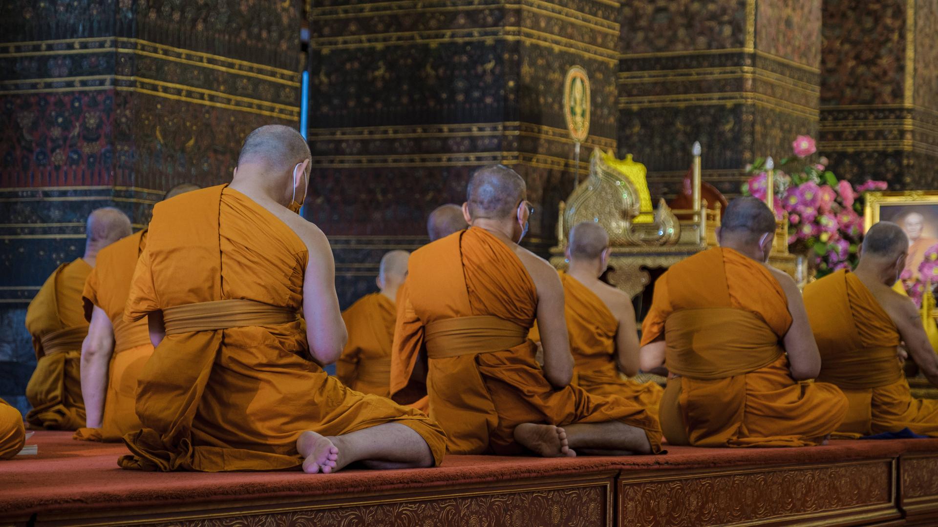 Buddhistische Mönche meditieren im Wat Pho Tempel in Bangkok.