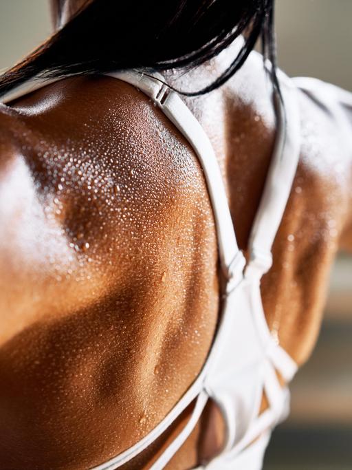 Nahaufnahme der Rückenmuskulatur und des trainierten Biceps einer Bodybuilderin