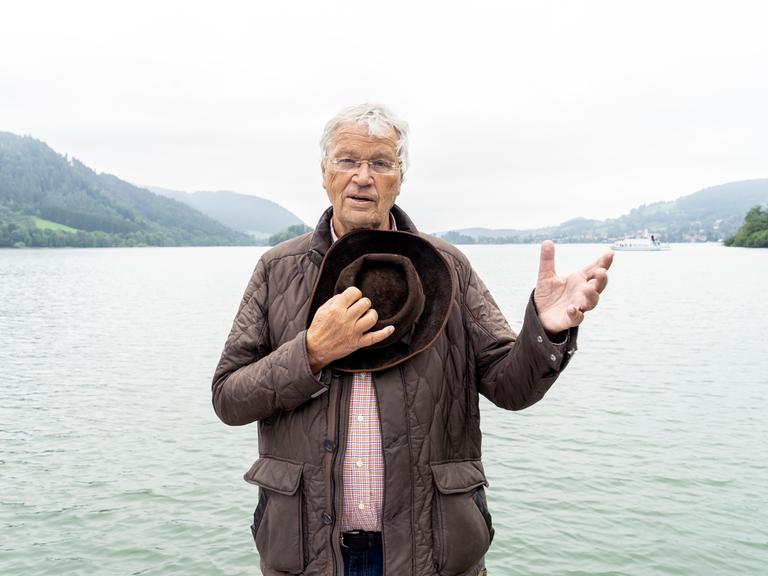Porträt von Gerhard Polt vor einem bayerischen See.