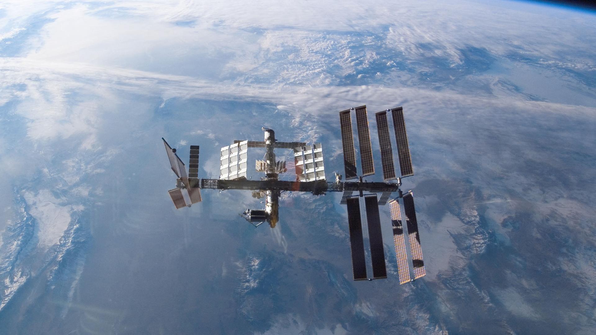 Die Weltraumstation ISS scheint über der Erde zu schweben. Die Weltraumstation ISS scheint über der Erde zu schweben.