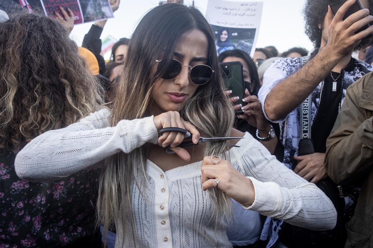 Eine Frau schneidet sich die öffentlich die langen Haare ab auf einer Demonstration gegen den Tod von Mahsa Amini im Iran. Türkei, Istanbul, 2.Oktober 202. Eine Frau schneidet sich die öffentlich die langen Haare ab auf einer Demonstration gegen den Tod von Mahsa Amini im Iran. Türkei, Istanbul, 2.Oktober 202.