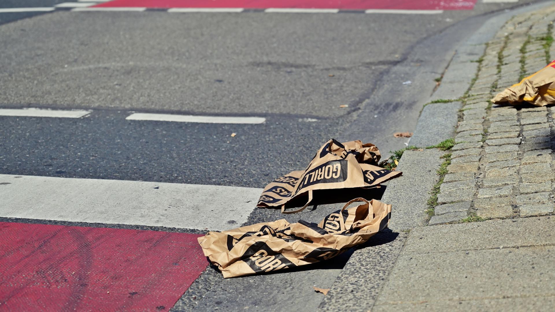 Leere Tüten des 2020 Gegründeten Lieferdienstes "Gorillas" liegen weggeworfen auf der Straße.