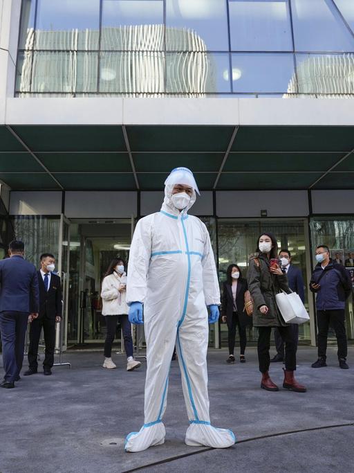 Ein Beamter in Schutzkleidung steht am 21. November 2022 in Peking vor einem Gebäude, das im Rahmen der Null-COVID-19-Politik der chinesischen Regierung geschlossen wurde. (Kyodo)