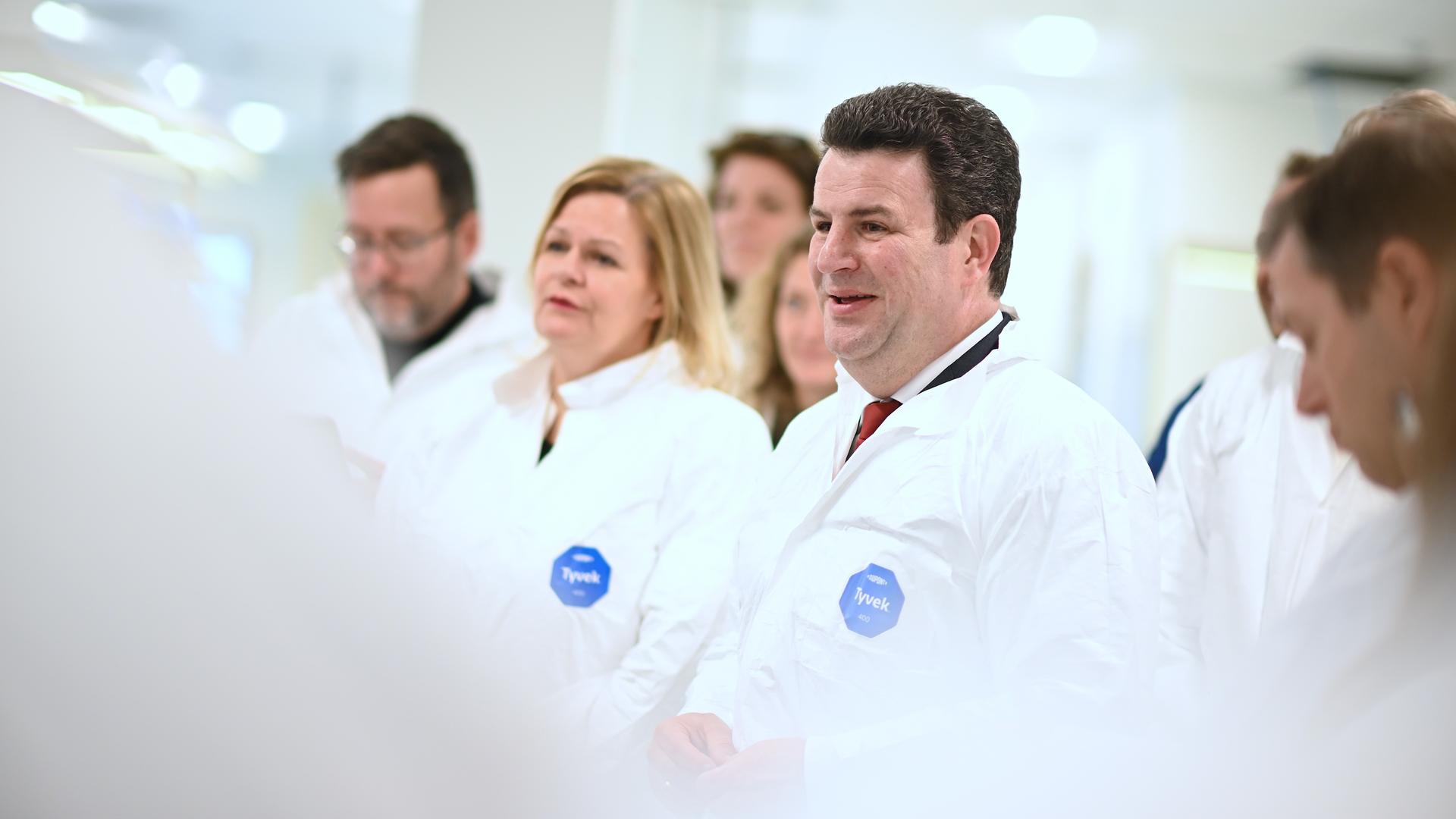 Nancy Faeser (SPD, 2.v.l.), Bundesministerin des Innern und Heimat, und Hubertus Heil (SPD, M), Bundesminister für Arbeit und Soziales, sprechen bei einem Unternehmensbesuch bei der Firma Siemens Healthineers mit den Mitarbeitern. Nancy Faeser (SPD, 2.v.l.), Bundesministerin des Innern und Heimat, und Hubertus Heil (SPD, M), Bundesminister für Arbeit und Soziales, sprechen bei einem Unternehmensbesuch bei der Firma Siemens Healthineers mit den Mitarbeitern.