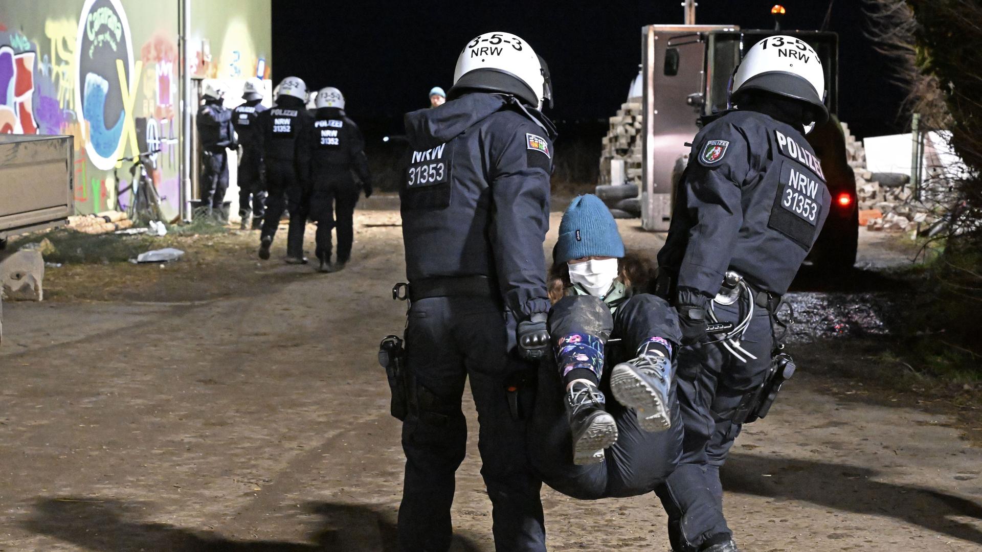 Zwei Polizisten tragen einen Menschen. Zwei Polizisten tragen einen Menschen.