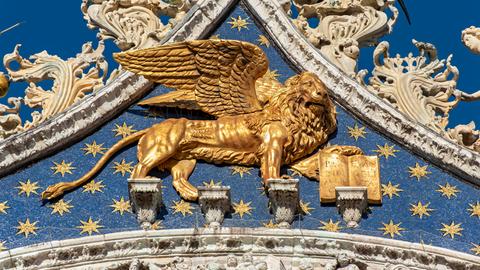 Ein goldener geflügelter Löwe am Markusdom in Venedig