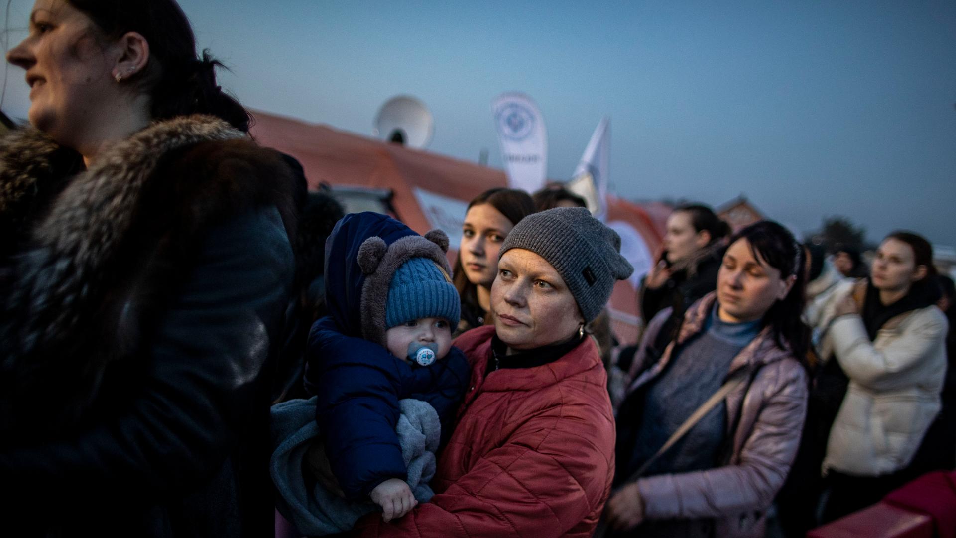 Frauen aus der Ukraine mit ihren Kindern warten kurz hinter der Grenze zur Ukraine, darauf, von Helfern in Empfang genommen zu werden. Frauen aus der Ukraine mit ihren Kindern warten kurz hinter der Grenze zur Ukraine, darauf, von Helfern in Empfang genommen zu werden.