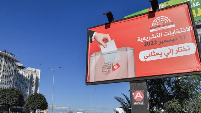 Fahrzeuge fahren in der tunesischen Hauptstadt Tunis an einem Banner vorbei, das die Menschen zur Teilnahme an der Parlamentswahl auffordert.