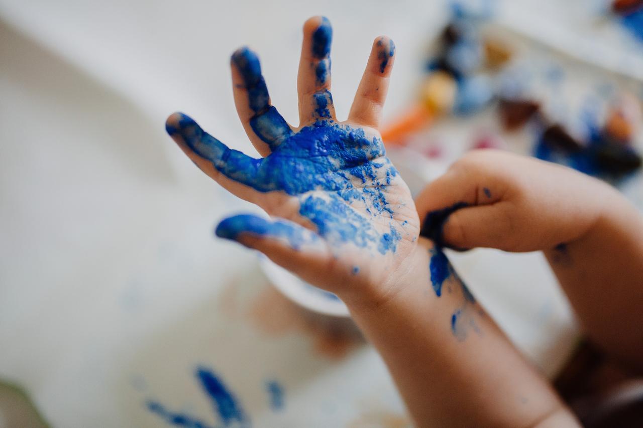 Eine mit blauer Farbe bemalte Kinder-Handfläche