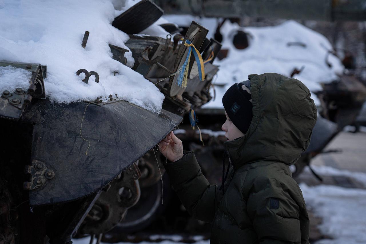 Kiew, Ukraine: Ein Junge steht im Winter neben einem zerstörten Fahrzeug der russischen Armee.
Kiew, Ukraine: Ein Junge steht im Winter neben einem zerstörten Fahrzeug der russischen Armee.