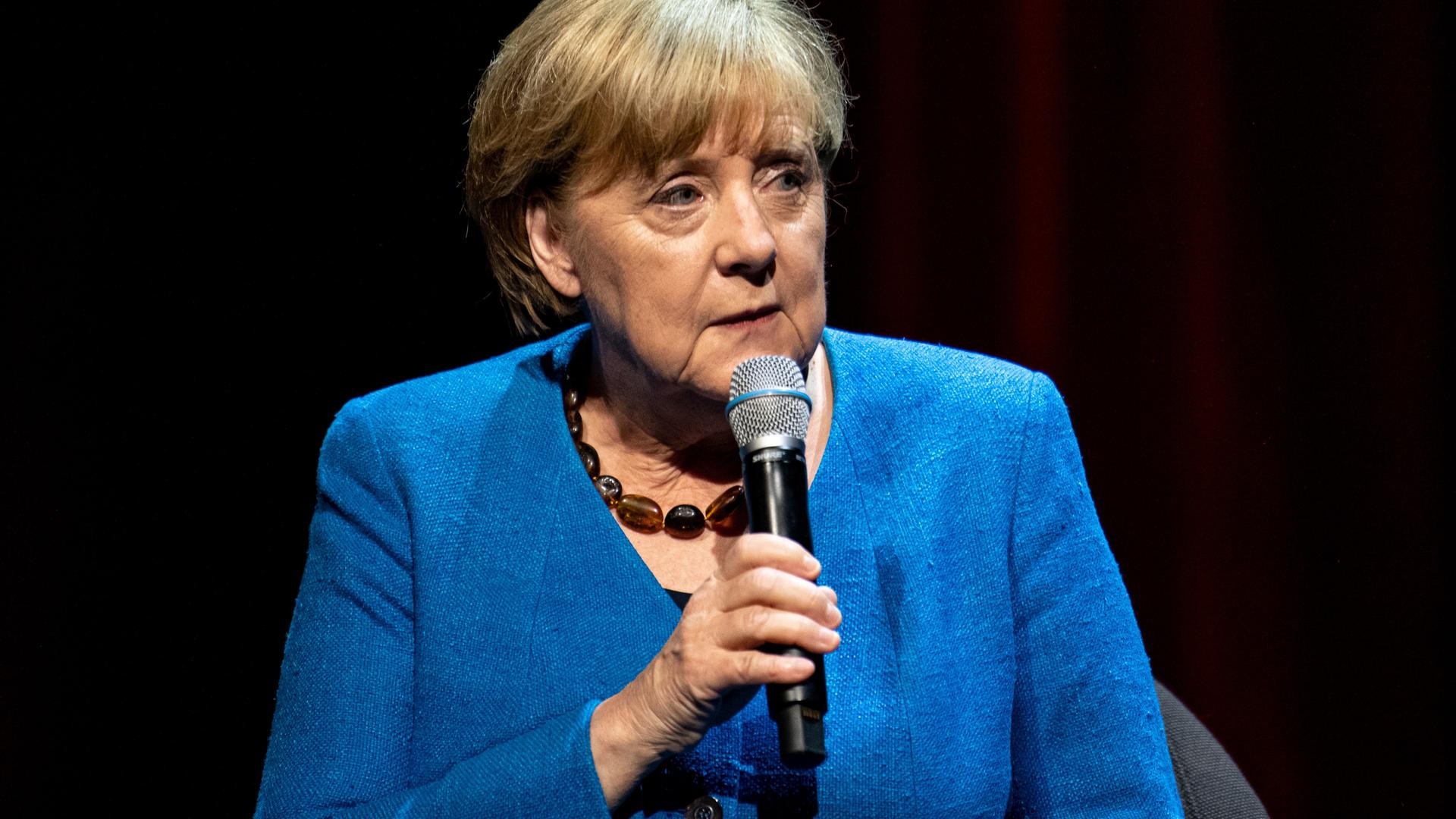 Porträt von Merkel mit Micro in der Hand.
