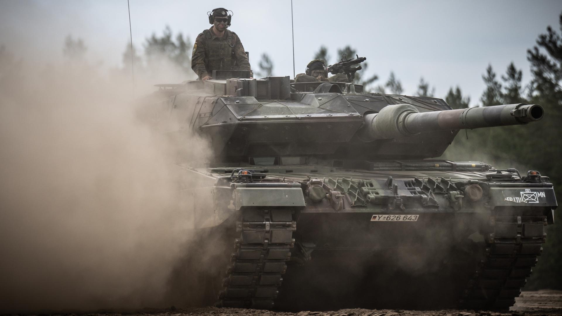 Aus einem fahrenden Leopard-2-Panzer schaut ein Soldat. Aus einem fahrenden Leopard-2-Panzer schaut ein Soldat.