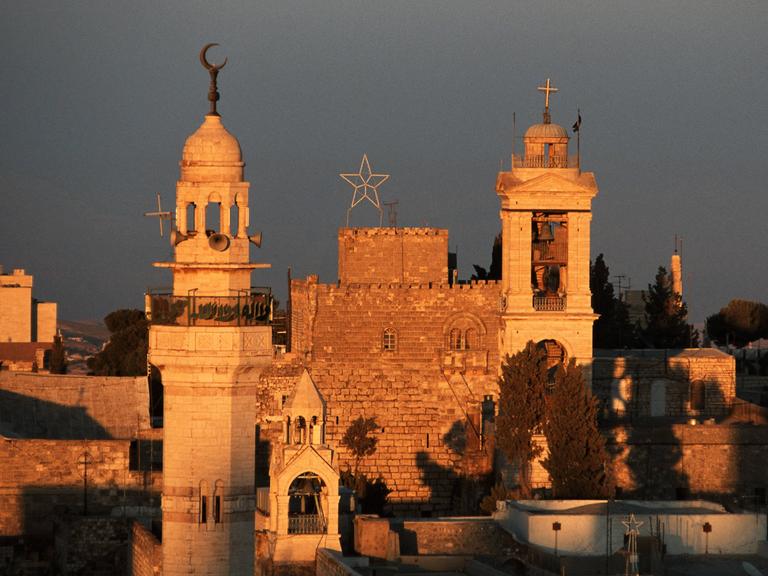 Minarett der Omar-Moschee (li.) vor der Geburtskirche (2.v.li.) dem St. Georgs Kloster und einer Kirche am Manger Square in Bethlehem.