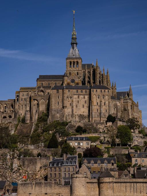 Die Abteikirche Mont Saint-Michel tront über mittelalterlichen Häusern inmitten des Meeres