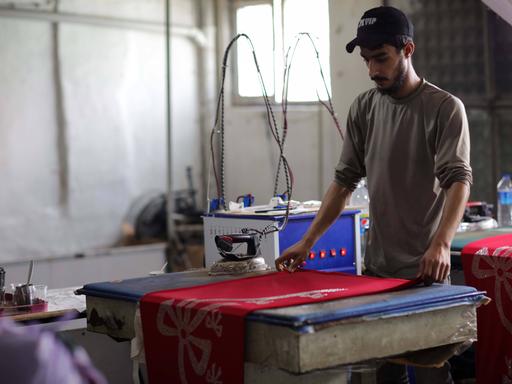 Eine Nähwerkstatt in der türkischen Stadt Gaziantep, die von Syrern gegründet wurde, die auf der Suche nach Sicherheit aus ihrem vom Krieg zerrütteten Land flohen. Einige junge syrische Kinder arbeiten auch mit ihren Vätern in der kleinen Fabrik, die hochwertige Kleidungsstücke und Coronavirus-Schutzkittel für den Export in den Irak und andere arabische Länder herstellt. Syrer haben sehr unter dem Konflikt, der Vertreibung und dem Kampf ums Überleben in einem anderen Land gelitten, wobei Kinder oft arbeiten müssen und die Schule verpassen, um zum Einkommen ihrer Familie beizutragen.