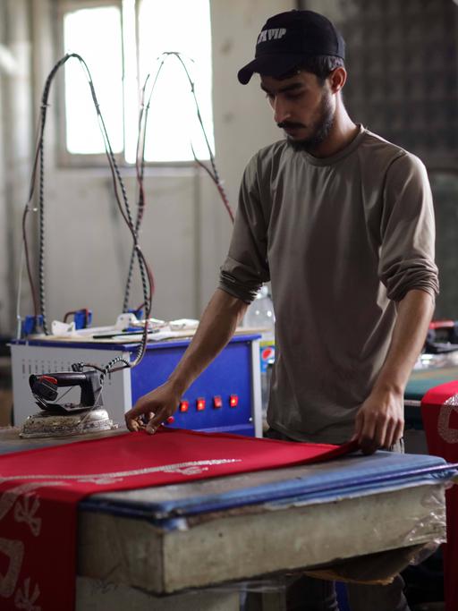 Eine Nähwerkstatt in der türkischen Stadt Gaziantep, die von Syrern gegründet wurde, die auf der Suche nach Sicherheit aus ihrem vom Krieg zerrütteten Land flohen. Einige junge syrische Kinder arbeiten auch mit ihren Vätern in der kleinen Fabrik, die hochwertige Kleidungsstücke und Coronavirus-Schutzkittel für den Export in den Irak und andere arabische Länder herstellt. Syrer haben sehr unter dem Konflikt, der Vertreibung und dem Kampf ums Überleben in einem anderen Land gelitten, wobei Kinder oft arbeiten müssen und die Schule verpassen, um zum Einkommen ihrer Familie beizutragen.