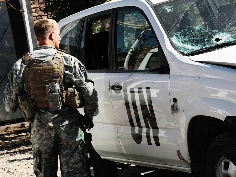 Ein amerikanischer UN Soldat steht neben einem Auto mit zerstörter Windschutzscheibe in Herat, Afghanistan, 2010.