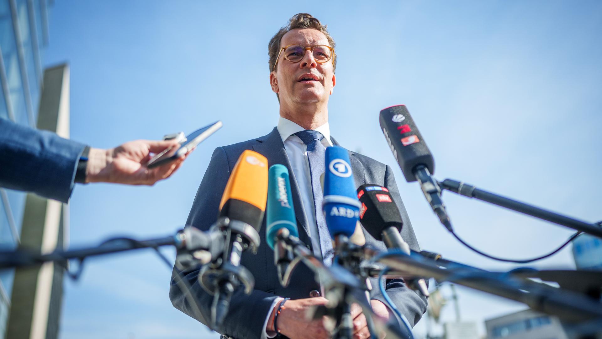 Hendrik Wüst (CDU), Ministerpräsident von Nordrhein-Westfalen, steht vor Mikrofonen im Freien und spricht. Hendrik Wüst (CDU), Ministerpräsident von Nordrhein-Westfalen, steht vor Mikrofonen im Freien und spricht.