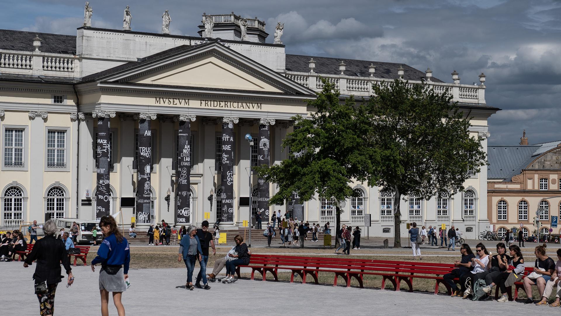 Besucher der documenta fifteen stehen vor dem Museum Fridericianum in Kassel. Besucher der documenta fifteen stehen vor dem Museum Fridericianum in Kassel.