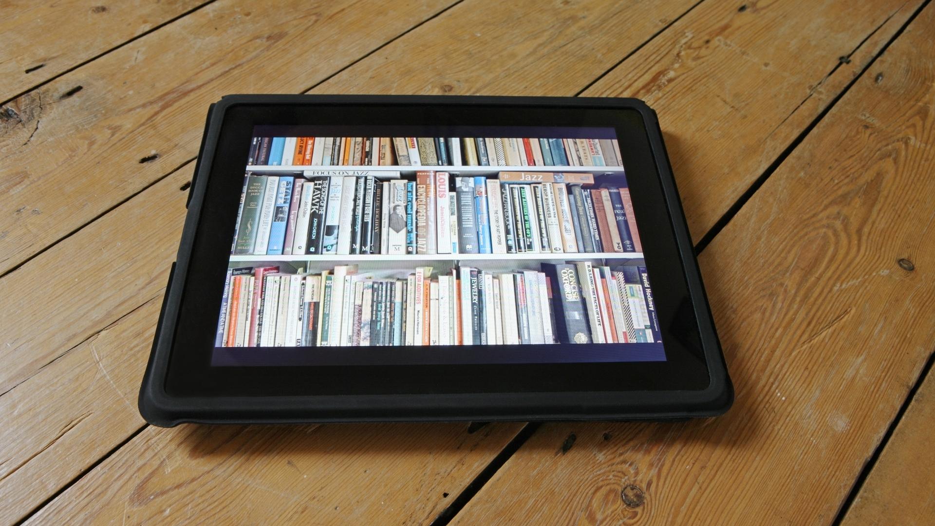 Auf einem Tablet wird ein ganzes Bücherregal dargestellt.