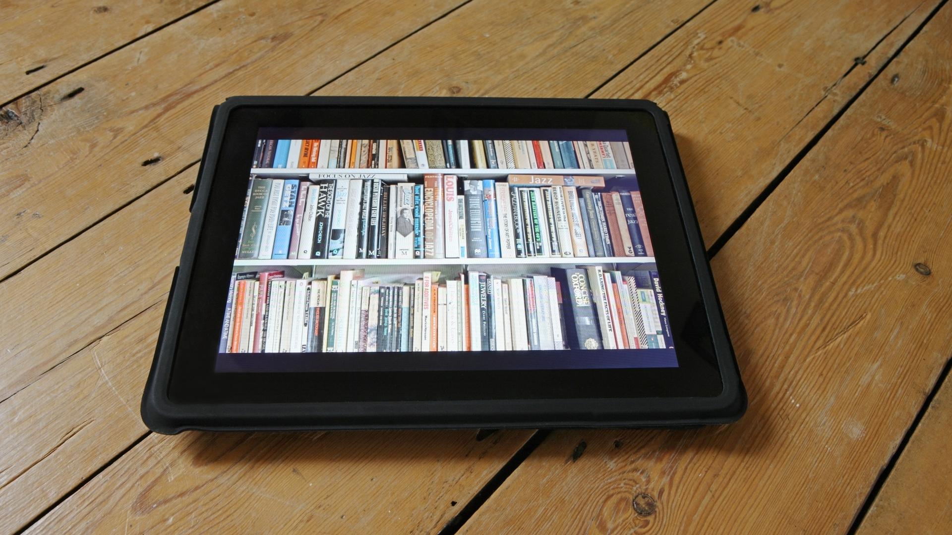 Auf einem Tablet wird ein ganzes Bücherregal dargestellt. Auf einem Tablet wird ein ganzes Bücherregal dargestellt.