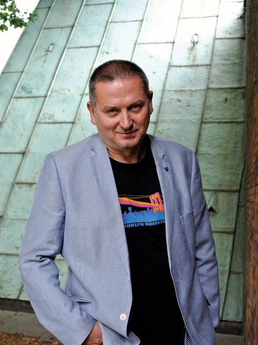 Georgi Gospodinov grinst in die Kamera. Er hat eine Hand in seiner Hosentasche.