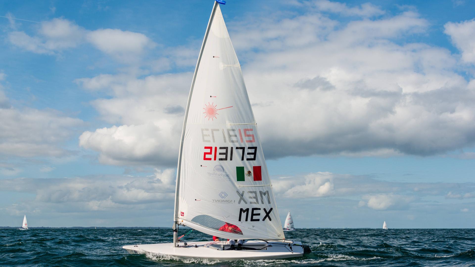Ein kleines Segelboot mit einem Segelmast auf dem Meer während einer Regatta. Ein kleines Segelboot mit einem Segelmast auf dem Meer während einer Regatta.