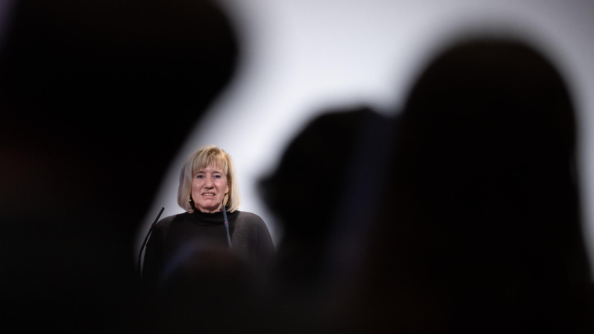 Ines Geipel steht vor dunklem Publikum bei einer Rede in Leipzig, 2023. Ines Geipel steht vor dunklem Publikum bei einer Rede in Leipzig, 2023.