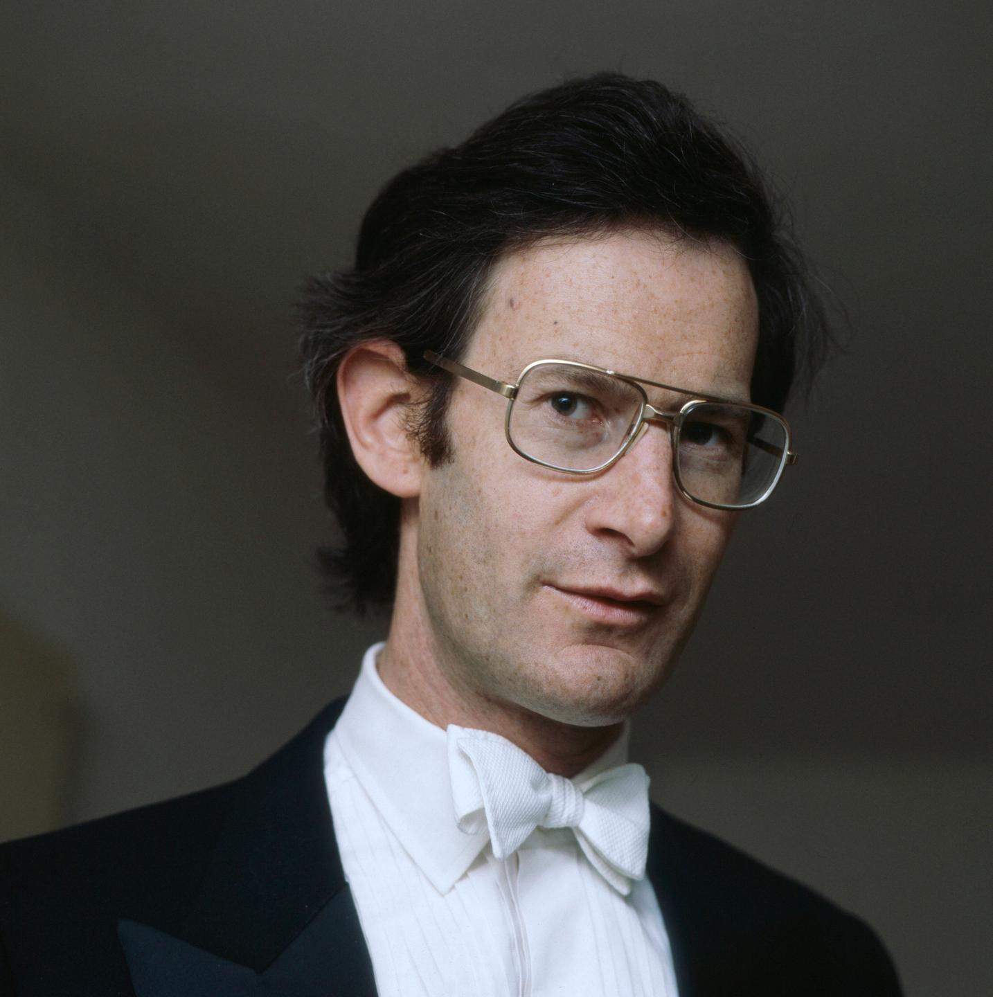 Der jüngere Dirigent John Eliot Gardiner blickt mit großer Brille und dunklem Haar in die Kamera.
