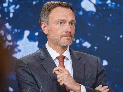 Bundesfinanzminister Christian Lindner FDP im Portrait bei der Pressekonferenz nach der Klausurtagung des Bundeskabinetts vor blauen Hintergrund.