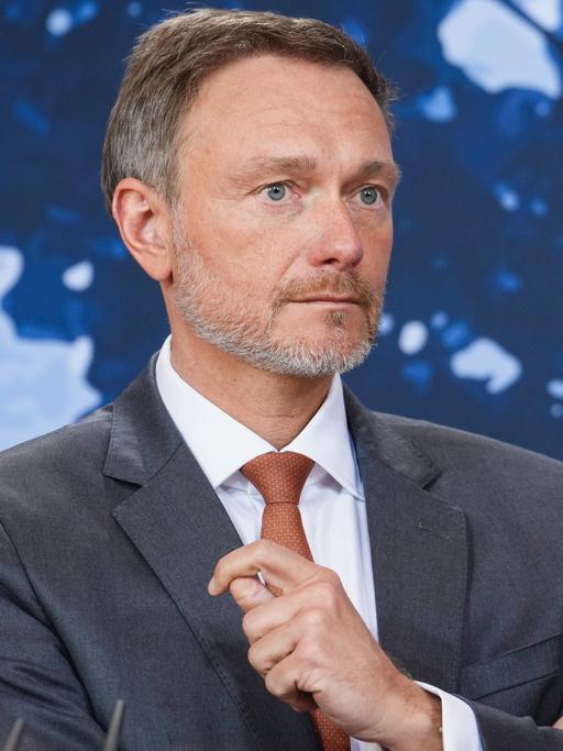 Bundesfinanzminister Christian Lindner FDP im Portrait bei der Pressekonferenz nach der Klausurtagung des Bundeskabinetts vor blauen Hintergrund.