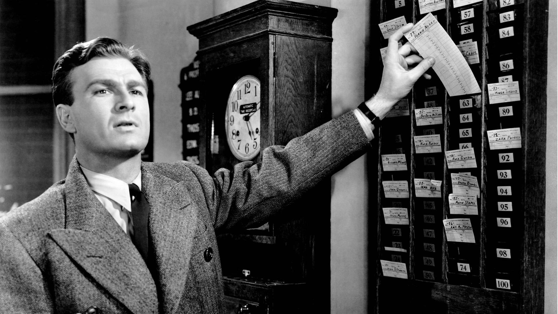 Ein Mann bedient eine Stechuhr (Szene aus dem Film "The Great Mr. Nobody" von 1941) Ein Mann bedient eine Stechuhr (Szene aus dem Film "The Great Mr. Nobody" von 1941)