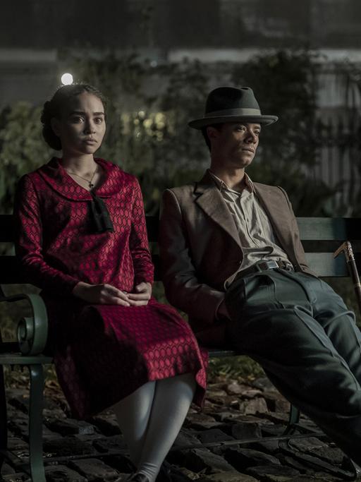 Die drei Hauptdarsteller der Serie "Interview with the Vampire" sitzen nebeneinander auf einer Parkbank: Eine junge, afroamerikanische Frau, ein afroamerikanischer Mann und ein hellhaariger Mann. Es sind die drei Hauptdarsteller Bailey Bass, Jacob Anderson und Sam Reid.