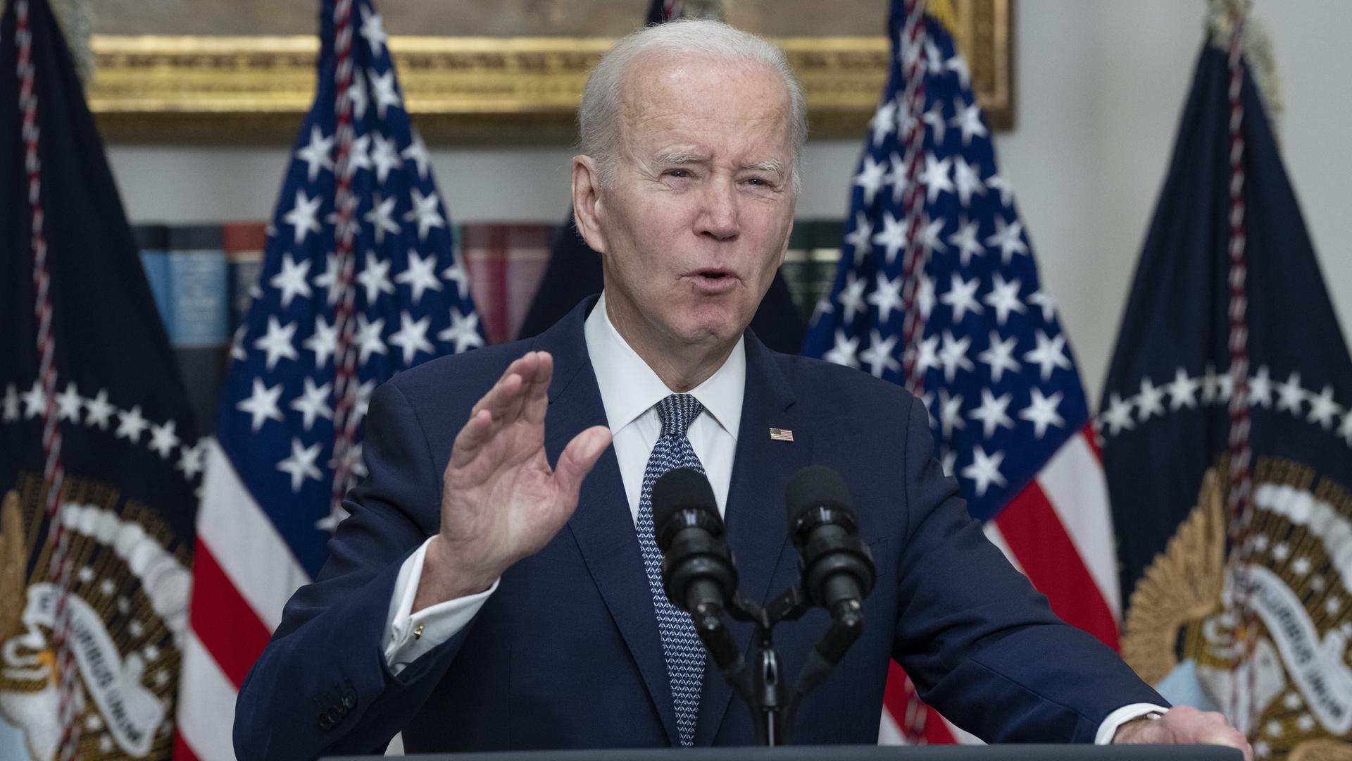 US-Präsident Joe Biden macht eine beschwichtige Geste an einem Rednerpult, hinter ihm die amerikanische Flagge. US-Präsident Joe Biden macht eine beschwichtige Geste an einem Rednerpult, hinter ihm die amerikanische Flagge.