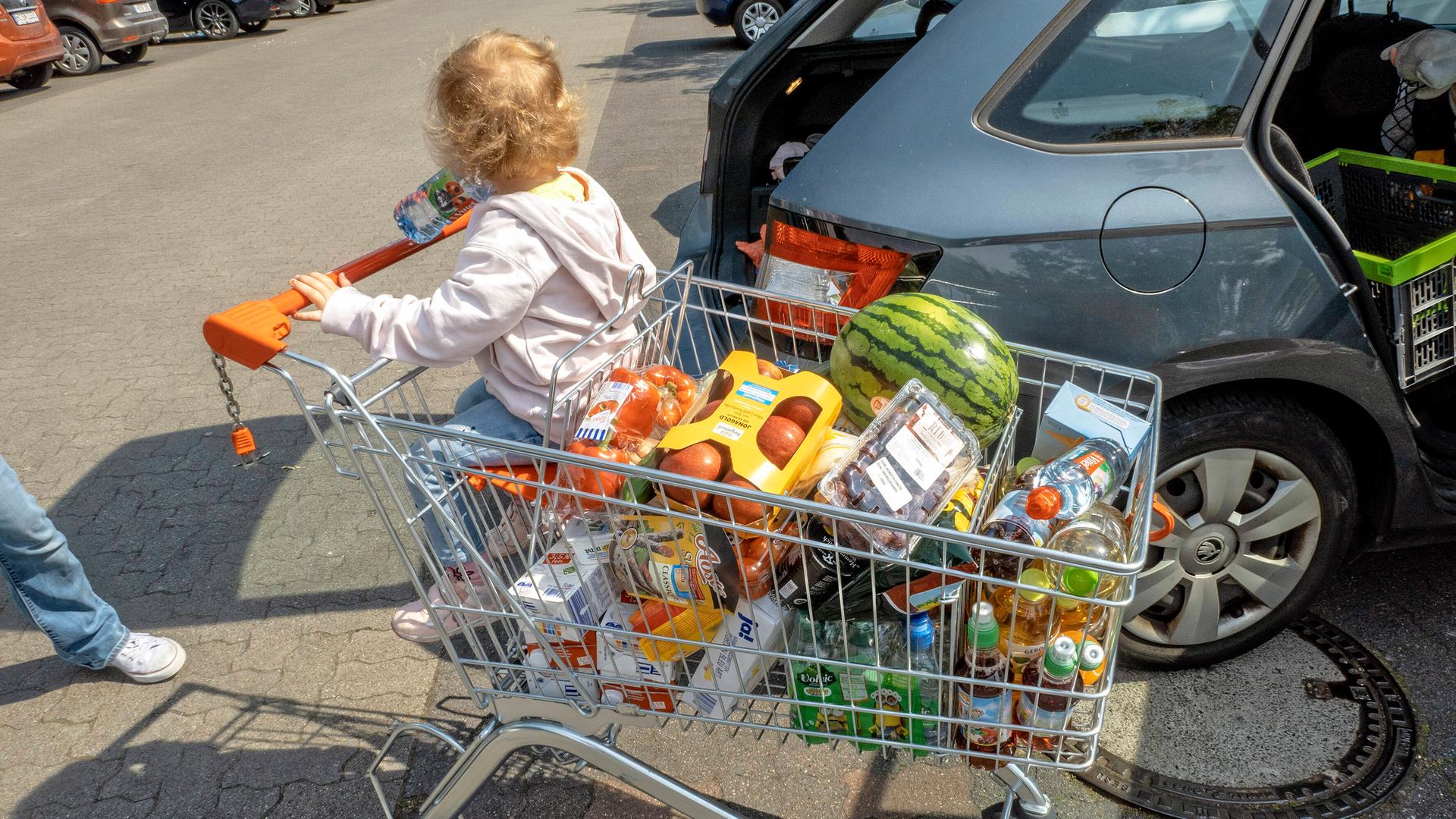 Ein voller Einkaufswagen samt Kind Ein voller Einkaufswagen samt Kind