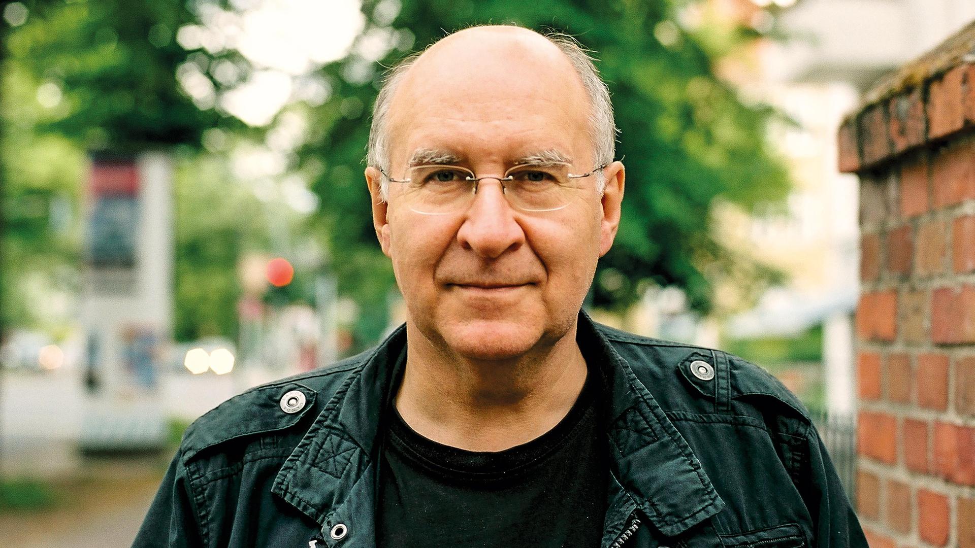 Der Autor Peter Wensierski, ein Mann mit kahlem Kopf und Brille schaut ernst. Der Autor Peter Wensierski, ein Mann mit kahlem Kopf und Brille schaut ernst.
