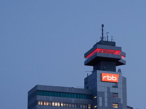Das beleuchtete Logo des Senders Rundfunk Berlin-Brandenburg (RBB) ist an der Fassade am Sitz des Senders an der Masurenallee angebracht