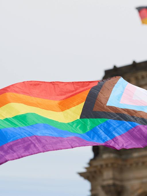 Eine LGBTQ-Regenbogenfahne vor dem Reichstagsgebäude in Berlin.