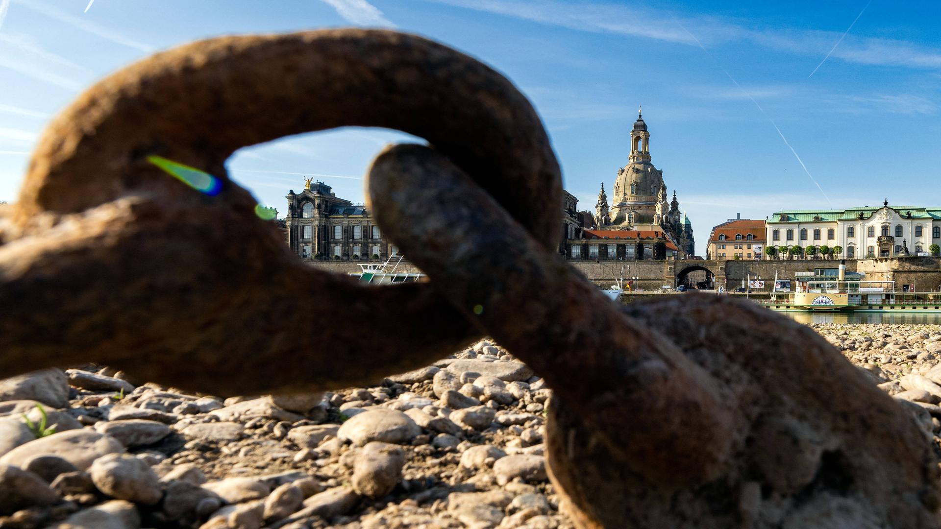 Durch eine verrostete Schiffskette kann der Blick über den Fluss schweifen, an dem das historische Dresden mit seiner Frauenkirche liegt. Durch eine verrostete Schiffskette kann der Blick über den Fluss schweifen, an dem das historische Dresden mit seiner Frauenkirche liegt.