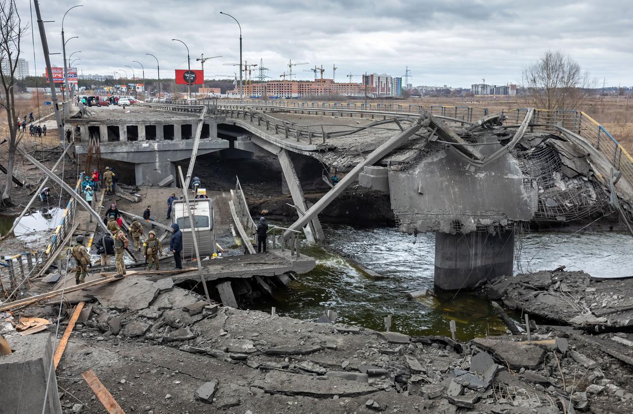 Krieg in der Ukraine: Bei der Evakuierung von Irpin überqueren flüchtende Menschen eine zerstörte Brücke. Krieg in der Ukraine: Bei der Evakuierung von Irpin überqueren flüchtende Menschen eine zerstörte Brücke.