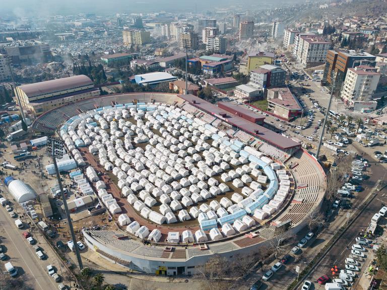 Ein Zeltlager im Innenraum des Fußballstadions in Kahramanmaraş aus der Vogelperspektive.