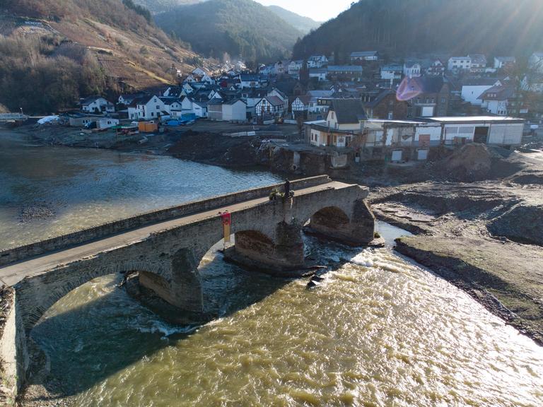 Eine Brücke über einen Fluss. Die Brücke ist eingestürzt und endet abrupt.